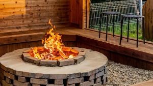 a fire pit in a deck with two stools at Gapyeong Ruba Pension in Gapyeong