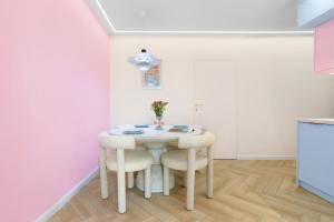 a white dining room with a white table and chairs at Pastel Apartment - Ergo Arena in Gdańsk +2 photos