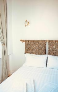 a bedroom with a white bed with white pillows at L'échelle Rouge in Cannes