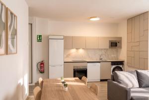 a kitchen and living room with a table and a couch at InsideHome Ciudad de Valladolid in Valladolid
