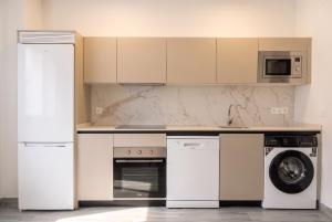 a kitchen with a stove and a washer and dryer at InsideHome Ciudad de Valladolid in Valladolid +155 photos
