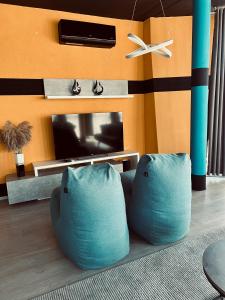 a living room with two blue pillows and a tv at L&A Apartments in Dragash