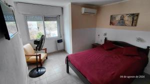 a bedroom with a red bed and a chair at Ayalata del Rio in Colón +28 photos