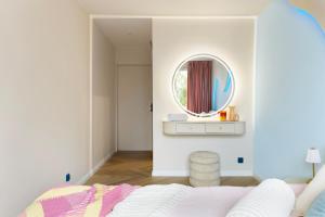 a bedroom with a bed and a mirror at Pastel Apartment - Ergo Arena in Gdańsk