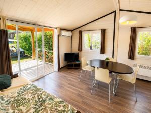 a room with a table and chairs and a bed at Chalet Riviera in Autruy-sur-Juine