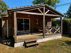 a wooden cabin with a porch and a deck at Chalet Riviera in Autruy-sur-Juine