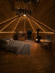 a bedroom with a bed and a fireplace in a room at Glamp and Tipple Ltd in Great Ellingham