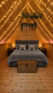 a bedroom with a bed in a wooden ceiling at Glamp and Tipple Ltd in Great Ellingham +171 photos