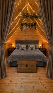 a bedroom with a bed in a wooden ceiling at Glamp and Tipple Ltd in Great Ellingham