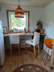 a kitchen with a table and chairs and a window at Vakker perle nær sjøen in Villanger