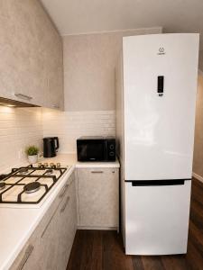 a kitchen with a white refrigerator and a stove at Люкс в центре Караганды in Karagandy +6 photos