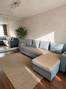 a living room with a blue couch and a mirror at Люкс в центре Караганды in Karagandy