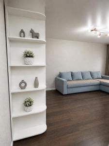 a living room with a blue couch in a room at Люкс в центре Караганды in Karagandy