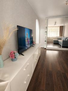 a living room with a large flat screen tv on a counter at Люкс в центре Караганды in Karagandy