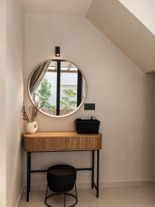 a round mirror on a table with a chair at athanasia sea view home front house in Polychrono
