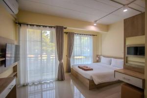 a bedroom with a bed and a large window at Wellness World Chiva Khao Yai in Ban Wang Sai