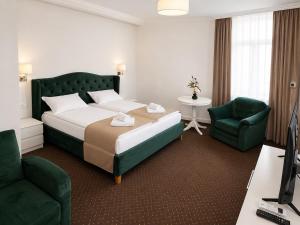 a hotel room with a bed and a desk and chair at HOTEL OPAL Zalau in Zalău +18 photos