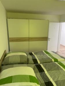 a bedroom with two beds and a large headboard at Pension am Schottenring in Schotten +3 photos