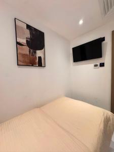 a bedroom with a bed and a flat screen tv at Vogue Inn in Abu Dhabi