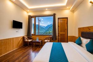 a hotel room with a bed and a large window at Hotel Biker Gang Hotel & Cafe in Kyelang +19 photos