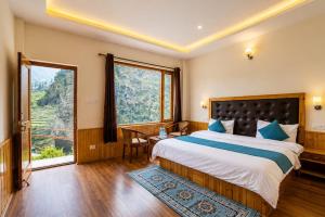 a bedroom with a large bed and a large window at Hotel Biker Gang Hotel & Cafe in Kyelang