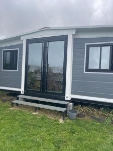 a mobile home with a porch and windows at Jardin de Meliss in La Plaine des Cafres