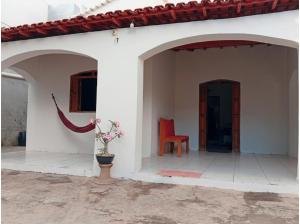 a white house with a red chair and a vase at Casa do Mandacaru in Bom Jesus da Lapa +10 photos