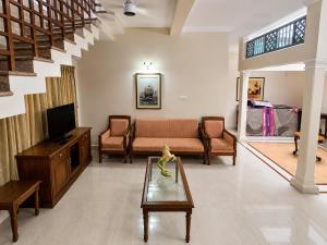 a living room with a couch and a tv at Sky Villa in Trichūr