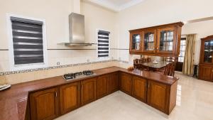a kitchen with wooden cabinets and a table in it at Sky Villa in Trichūr +10 photos