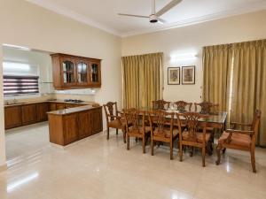 a kitchen and dining room with a table and chairs at Sky Villa in Trichūr