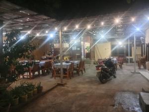 a motorcycle parked inside of a restaurant at night at Mamat warung bed & breakfast in Huu