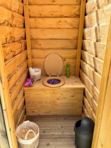 a wooden sauna with a toilet in the middle at Tipi du pied de loup in Clérey