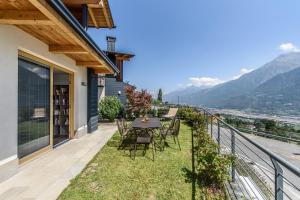 a dining table on the balcony of a house at Alpine Aura Loft- Privacy, Relax, Mountain View in Saint-Christophe