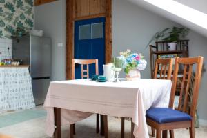 a kitchen with a table with a blue door at Leśniczówka Dobrocin in Małdyty +28 photos