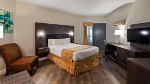 a hotel room with a large bed and a desk at Best Western Laval-Montreal in Laval