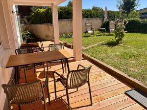 a wooden deck with a table and chairs on it at Ferienwohnung Rosengarten in Einbeck