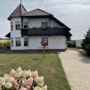 a white house with a balcony and some flowers at Ferienhaus Barth in Bad Salzungen