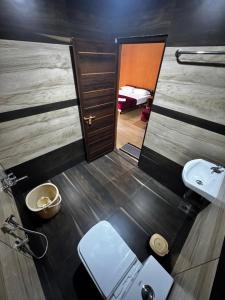 a bathroom with a mirror and a toilet and a sink at Marayoor Mud Castle in Maraiyūr