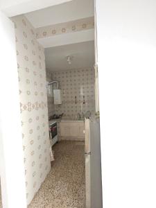 a kitchen with white walls and a refrigerator at Furnished accommodation S2 in Nabeul in Nabeul +7 photos
