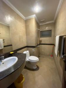 a bathroom with a white toilet and a sink at New Panoramic Hotel in Lahore +43 photos