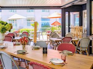 an empty restaurant with tables and chairs and tablesktop at Novotel Orléans Chemins De Sologne Demeures De Campagne in Orléans