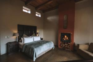 a bedroom with a bed and a fireplace at Tenahead Lodge & Spa in Rhodes