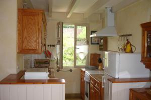 a kitchen with a white refrigerator and a window at Côté gartempe in Les Hermitières