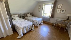 a bedroom with two beds and a window at Côté gartempe in Les Hermitières