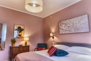 a bedroom with a bed and a painting on the wall at My Tuscany Pink Suite in San Quirico dʼOrcia