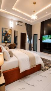 una camera da letto con un grande letto e una TV a schermo piatto di TOMA Hotel a Uyo
