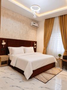 una camera da letto con un grande letto e un lampadario di TOMA Hotel a Uyo
