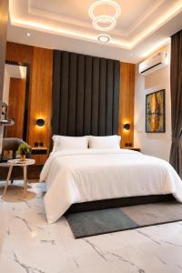 una camera da letto con un grande letto con una parete nera di TOMA Hotel a Uyo