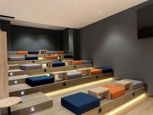 a lecture room with couches and tables and a screen at ibis budget Logroño Centro in Logroño
