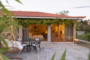 a patio with a table and chairs and a house at Quinta Linhas da Primavera in Guimarães
